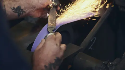 Scissor blade being sharpened