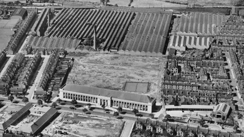 Black and white aerial shot of Howitt Building with Raleigh factories behind