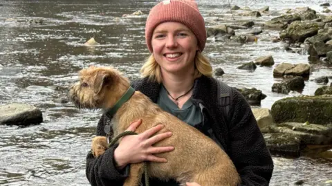 BBC A young woman holding a dog