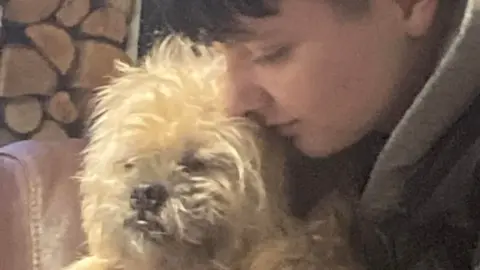 Family handout Family photo of James Pulman holding a dog.