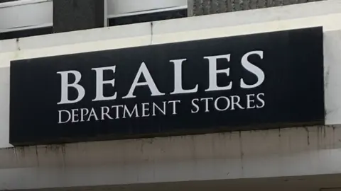 The black and white Beales shop sign.