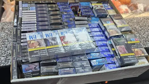 A box filled with packets of cigarettes in protective packaging.