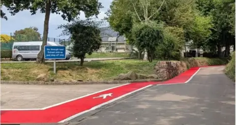 Andy Jay A red stripe with a white border on a lane next to a school