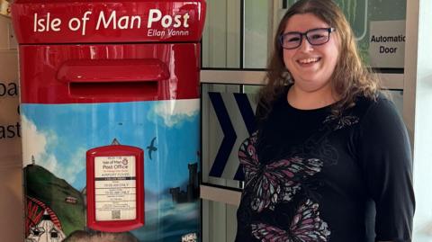 Victoria Thomas next to the post box with her design