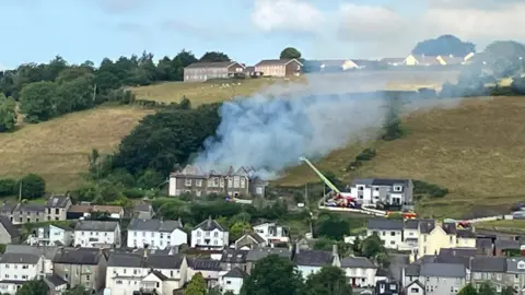 The abandoned school on Penwall Road in Llandysul in Ceredigion with smoke rising from the visibly collapsed roof. 