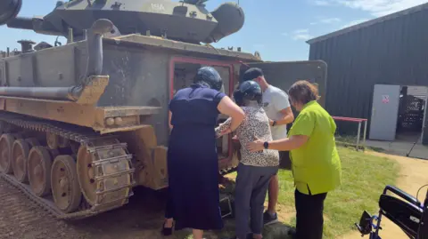 A pensioner climbing into a tank