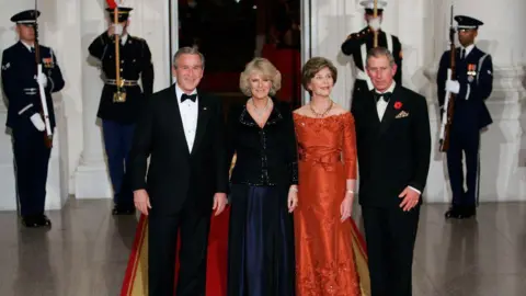 Getty Images George W Bush, the first lady, Queen Camilla and Charles. They are dressed nice, and standing on a red carpet