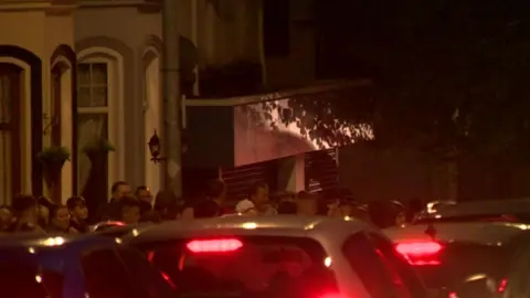 A large crowd gathered outside the estate agency on the Woodvale Road