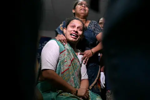 AFP via Getty Images Relatives mourn as they await DNA sample tests, for their loved ones to be identified, at an emergency centre in Ahmedabad on June 13, 2025, a day after Air India flight 171 crashed in a residential area. Rescue teams with sniffer dogs combed the crash site on June 13 of a London-bound passenger jet which ploughed into a residential area of India's Ahmedabad city, killing at least 265 people on board and on the ground. (Photo by Punit PARANJPE / AFP) (Photo by PUNIT PARANJPE/AFP via Getty Images)
