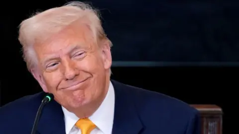 A smiling Trump at a lectern