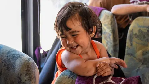 Child on board a bus in the convoy