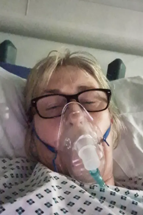 Amanda Evans Amanda wearing an oxygen mask in hospital