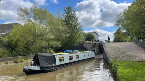 A canal boat leaving a loch.