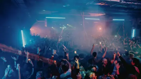 The Underground Club goers are pictured dancing to music at an underground venue.