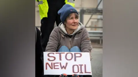 Just Stop Oil Dr Sarah Benn at the protest, holding a 'stop new oil' sign