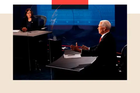 Getty Images Kamala Harris in a dark suit with her hands clasped sat at a desk while at a desk to the right of the picture Mike Pence, wearing a blue suit and red tie, gestures with his hands