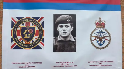 Simon Thake A large military banner with a black and white photo of an officer in the middle wearing a beret and military uniform