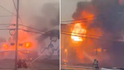 Firefighters are hosing down a building that caught on fire.