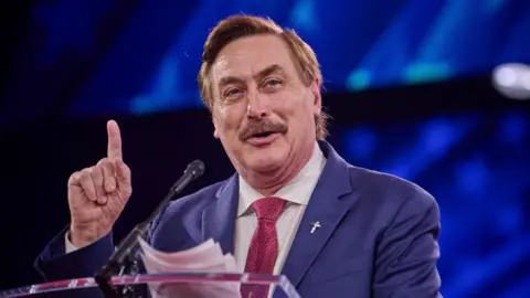 Mike Lindell raising a finger while speaking at the CPAC conference in February 2025