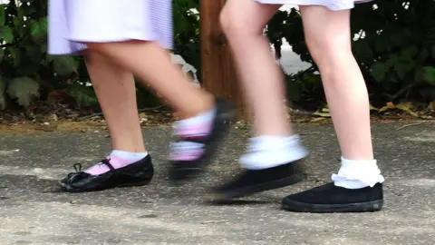 Close up of two children's feet in school shoes