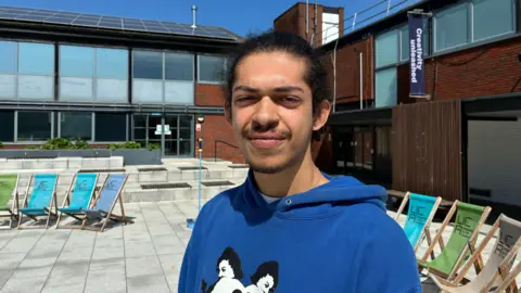 Zac Sherratt/BBC Maxwell Rhule, 21, graphic design student, looks straight at the camera.