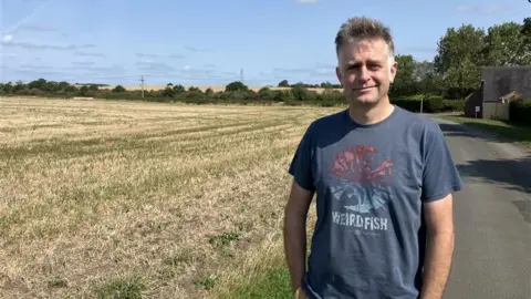 BBC Image of Duncan in front of a field close to where the development will be.