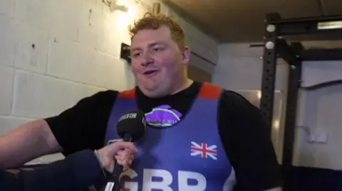 Ben Gibson wearing Great Britain leotard being interviewed by the BBC