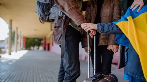 A Ukrainian refugee family in a railway station waits to leave Ukraine following the Russian invasion.