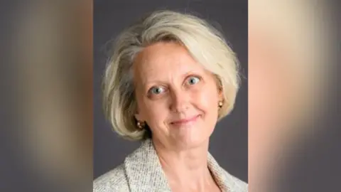 BCP Council Sharon Carr-Brown council headshot. She has medium length blonde hair and is standing in front of a grey background.
