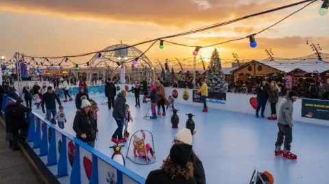 Visit Blackpool Families wearing winter clothing enjoy themselves on the skating rink at the Christmas by the Sea festival in Blackpool.