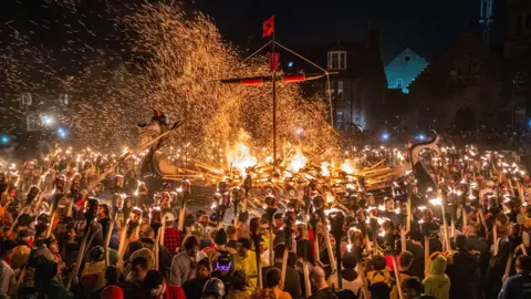 PA Media Hundreds of members of the Jarl Squad set fire to the galley