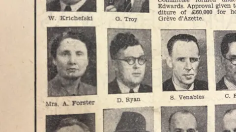 A close up of a newspaper clipping displaying many male headshots, and then one of Ivy Forster.