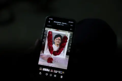 Reuters Prashant Patel, 45, shows a photo of his 17-year-old son Kahaan Patel, who took his own life ahead of the NEET exam retest, in Ahmedabad, India, July 21, 2026. REUTERS/Amit Dave