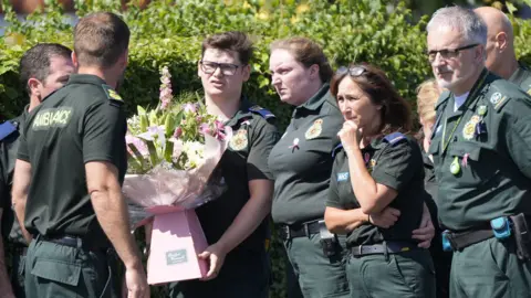 PA Media-Paramedic outside St. Patrick's Church with pink bouquet