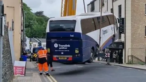 bus being lifted by crane