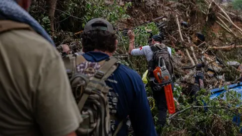 Men with backpacks search through the woods