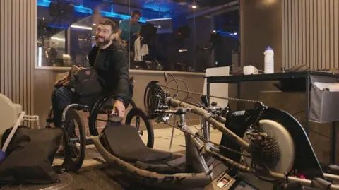 Stewarts Ollie Thorn training for Everest. He is in a wheelchair, next to the bike he will use when he goes on the mission.