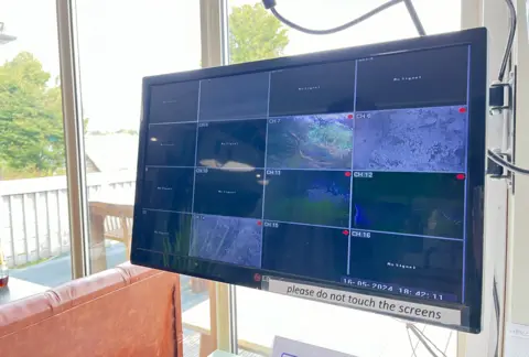 A monitor with 16 squares for 16 different camera feeds from the lake