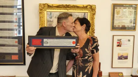 David Breakspear Photo of David kissing his partner Kelly holding the Freedom of the City Of London Award 