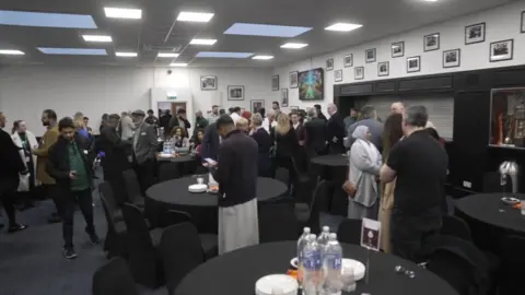Ant Saddington/BBC People inside attending the Iftar event at Kenilworth Road