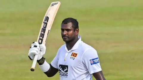 Angelo Mathews raising his bat. 