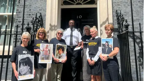 Six female campaigners who are part of the lobby group Anyone's Child. They are stood outside 10 downing street with a man who is collecting their letter.