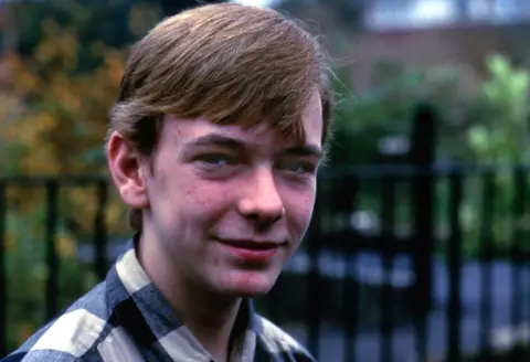 close up of adam woodyatt in 1985