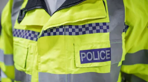A reflective police jacket being worn by an officer.