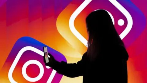 Silhouette of a young woman using a smartphone against a Instagram logo backdrop