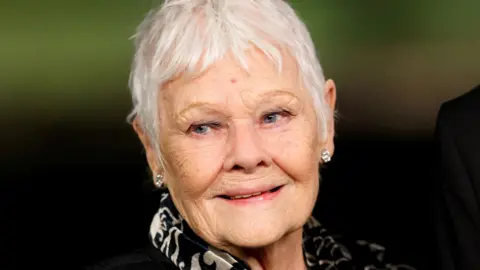 Dame Judi Dench, an ageing women with short, white hair 