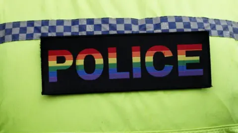 Getty Images A Northumbria Police officer wearing a Pride badge. The badge is a black rectangle with the word POLICE written in the colours of the rainbow flag.