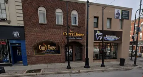 Google The exterior of a restaurant called the Curry House, a brick building set between two shops