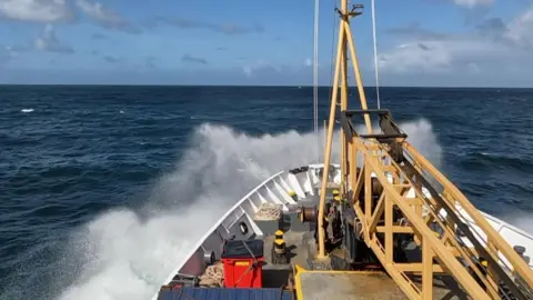 Spray plumes over the white bow of the Scillonian
