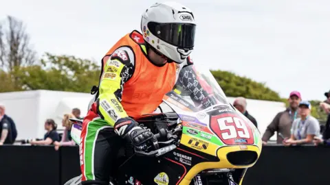 Mauro Poncini on his racing bike. He is wearing an orange newcomers bib over his leathers. The bike has 59 on the front.